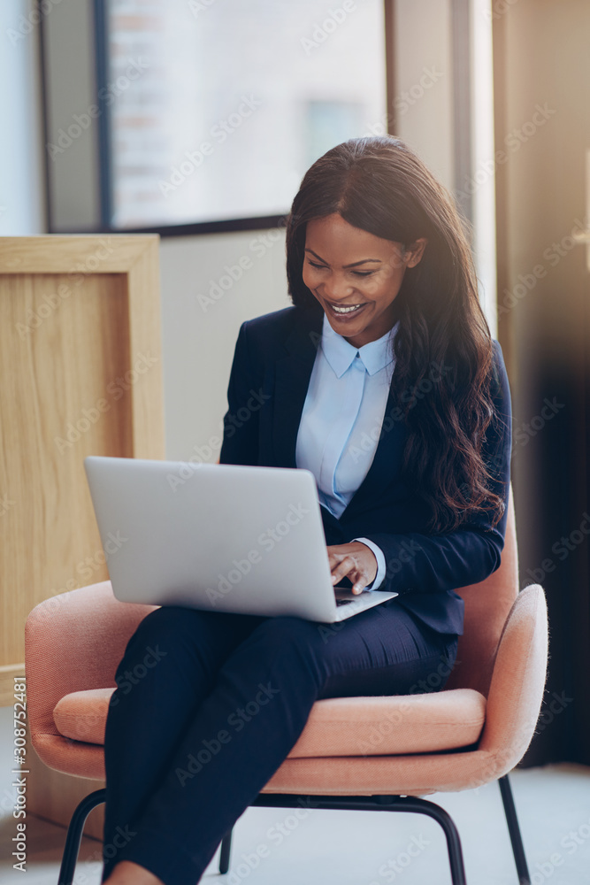 Smiling African American businesswoman working online in an offi