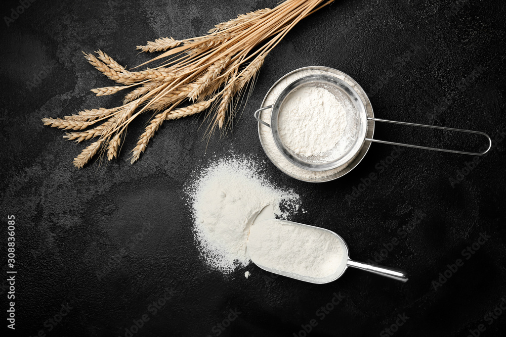 Flour with wheat spikelets on dark background