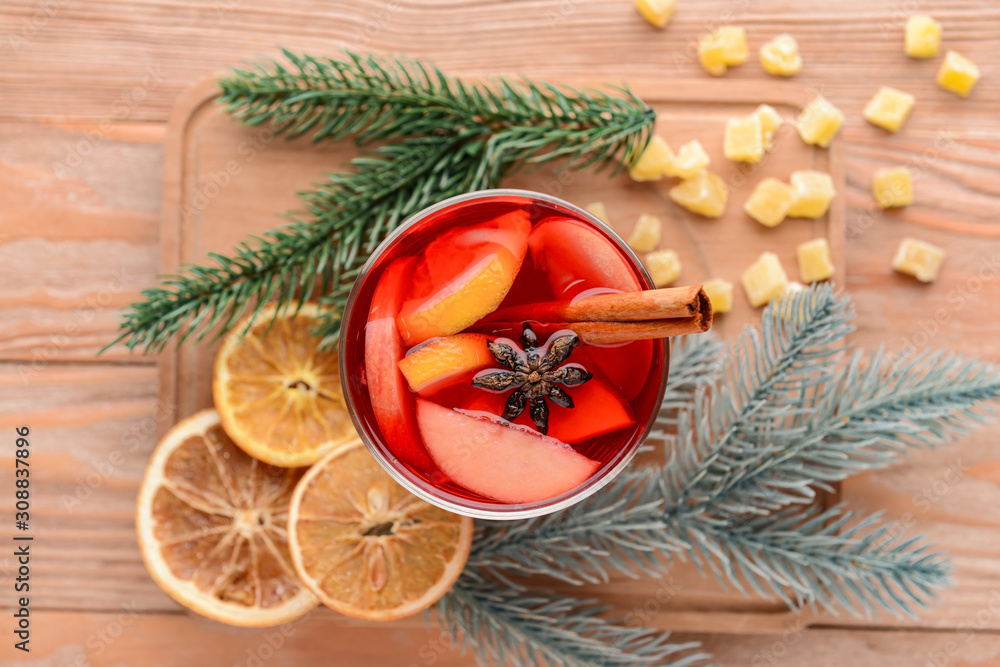 Glass of tasty mulled wine on wooden background