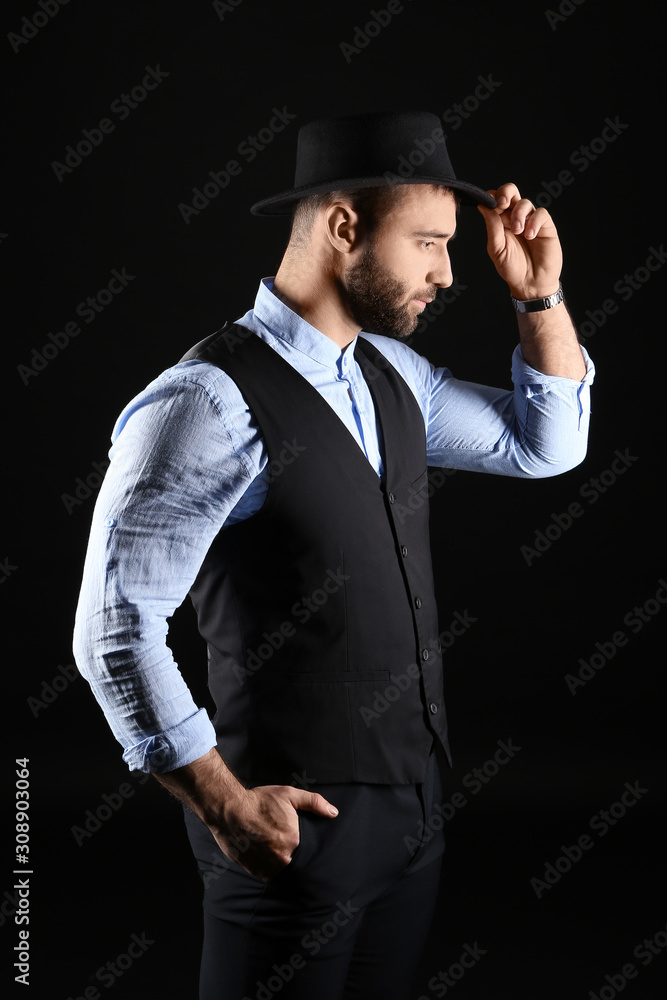 Portrait of stylish young man on dark background