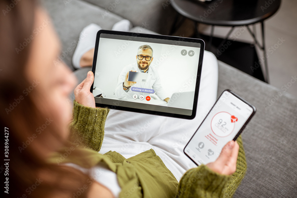 Woman making video call to a doctor using digital tablet, feeling bad at home. Concept of telemedici