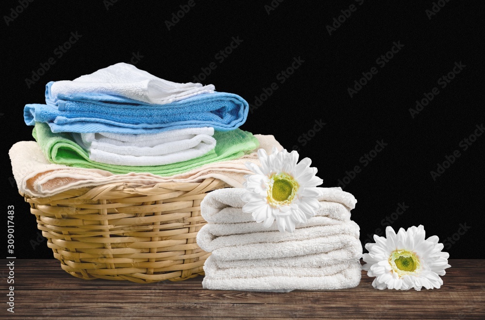 Laundry Basket with colorful towels on background