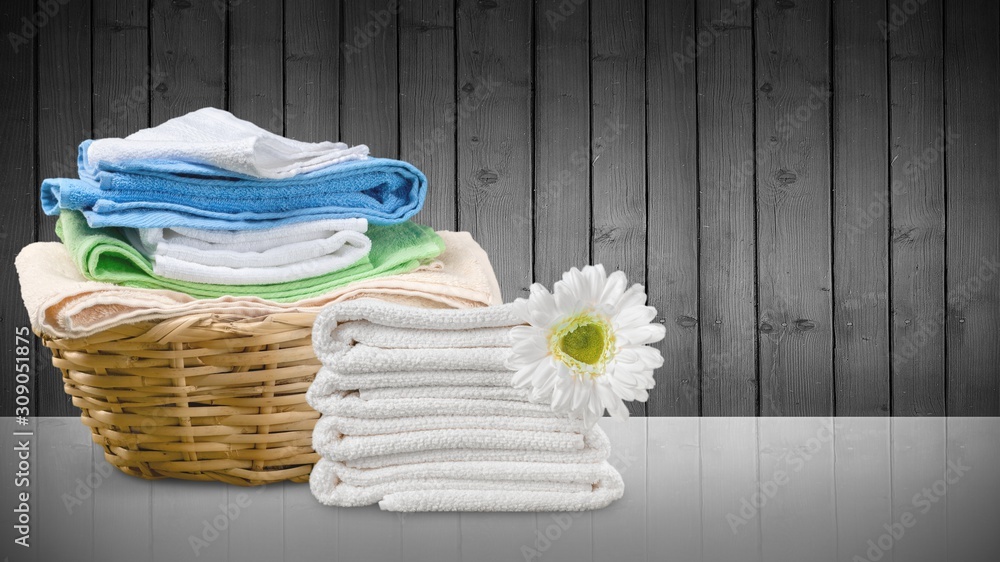 Laundry Basket with colorful towels on background