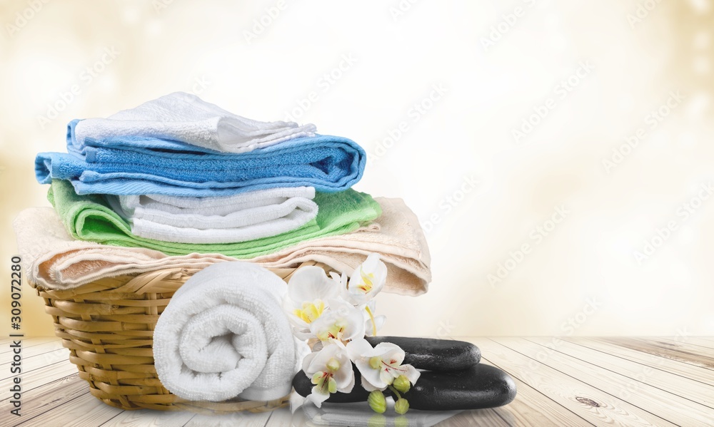 Laundry Basket with colorful towels on background