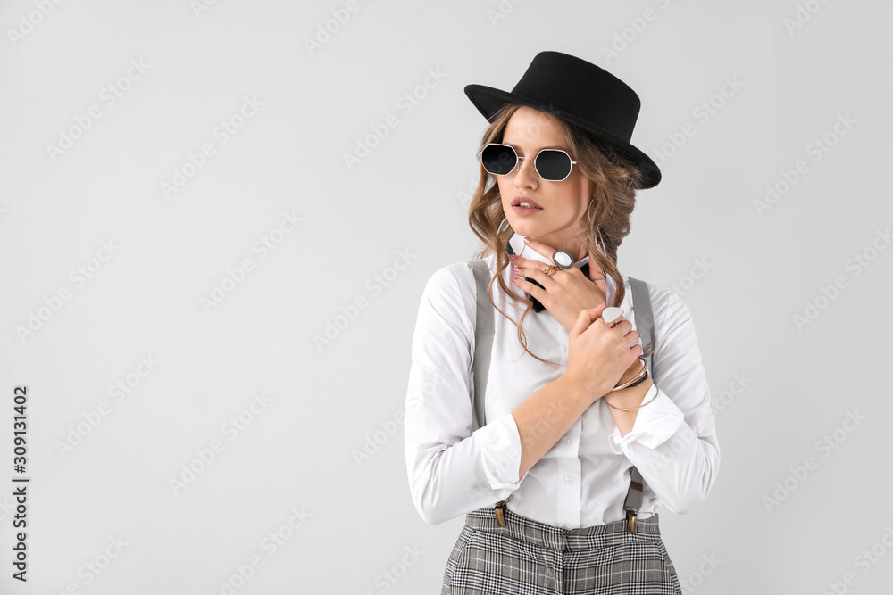 Fashionable young woman on light background