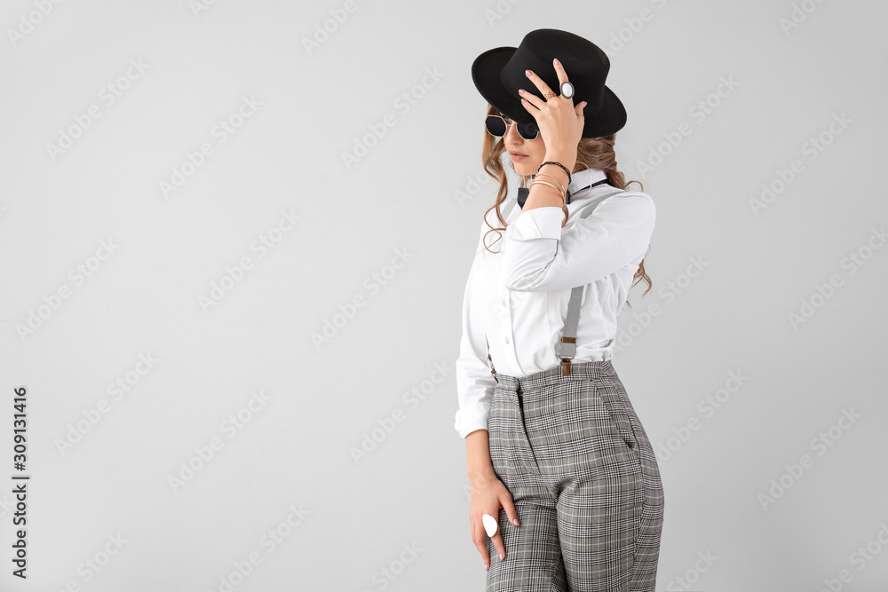 Fashionable young woman on light background