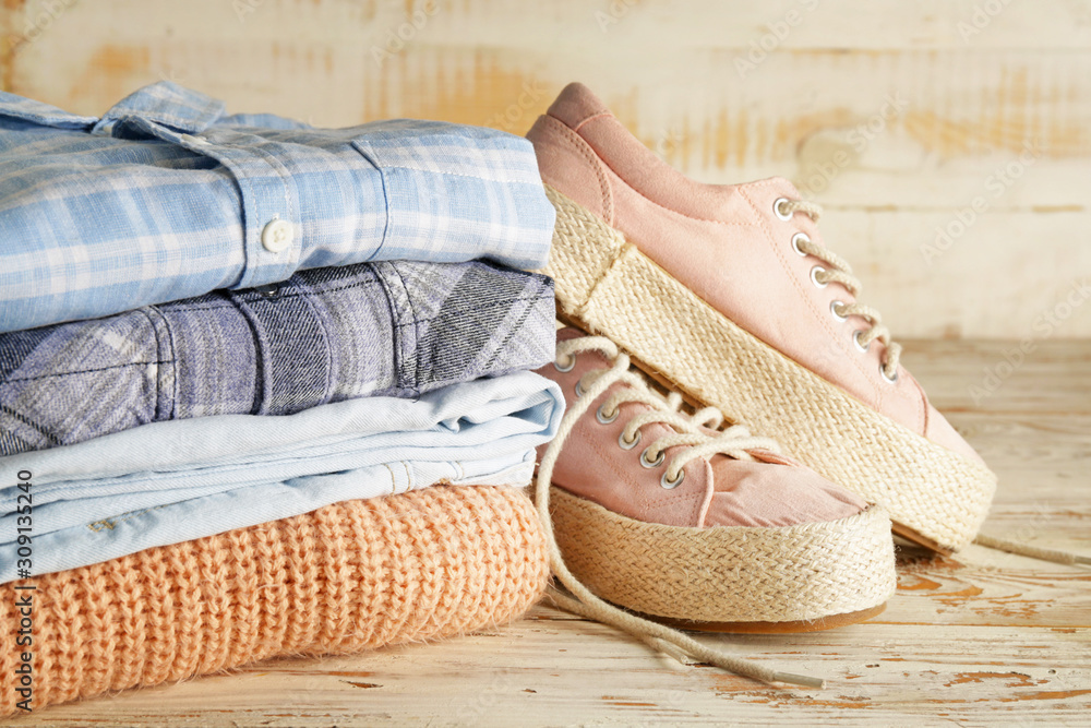 Stack of clothes and shoes on table