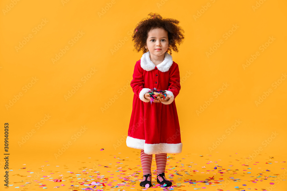 彩色背景上穿着圣诞老人服装的非洲裔美国小女孩