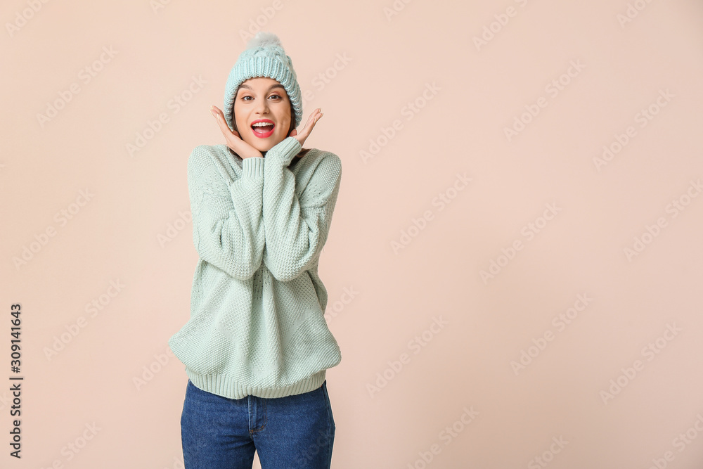 Happy young woman in winter clothes on light background