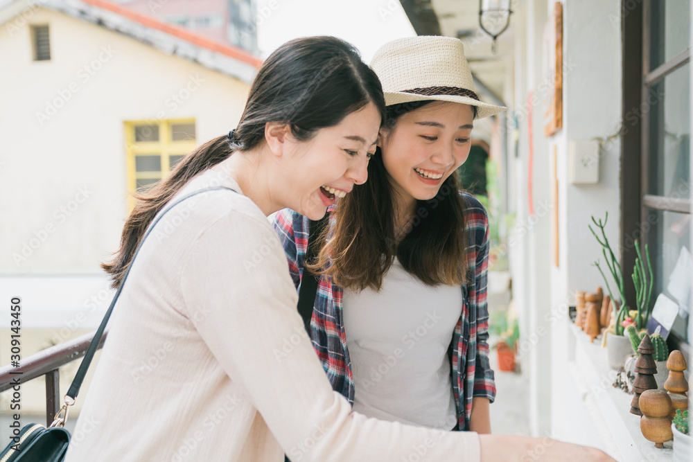 两位年轻的亚裔日本女性朋友站在小村庄ho的走廊上的肖像