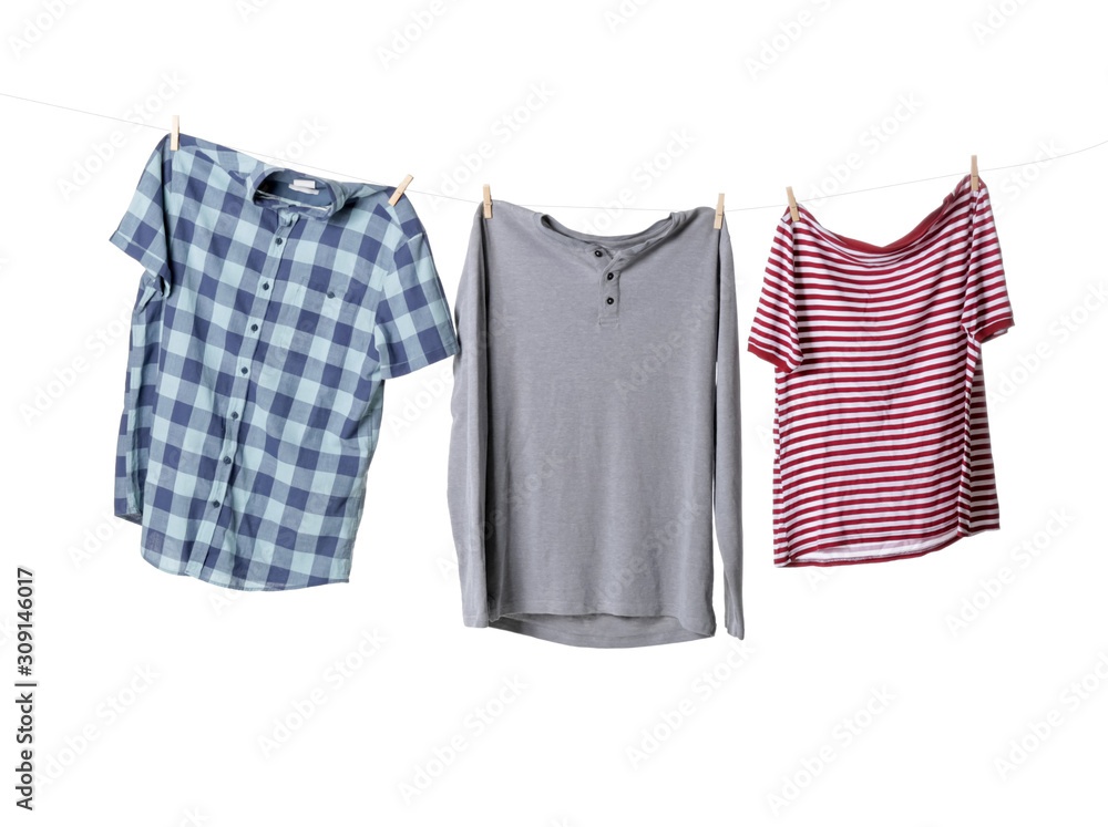 Clean clothes hanging on rope against white background