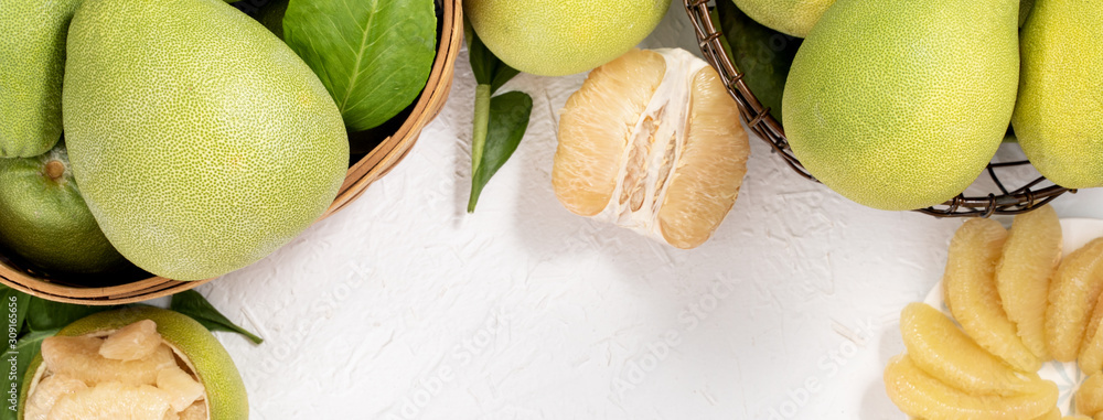 Fresh peeled pomelo, pummelo, grapefruit, shaddock on bright wooden background. Autumn seasonal frui