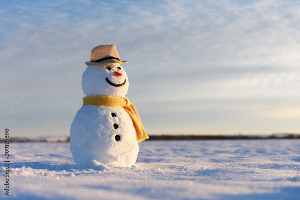 雪地上戴着时髦帽子、长着黄色鳞片的有趣雪人。圣诞快乐，新年快乐！