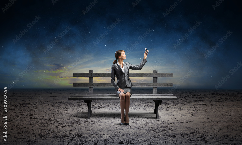 Young woman in business suit holding smartphone