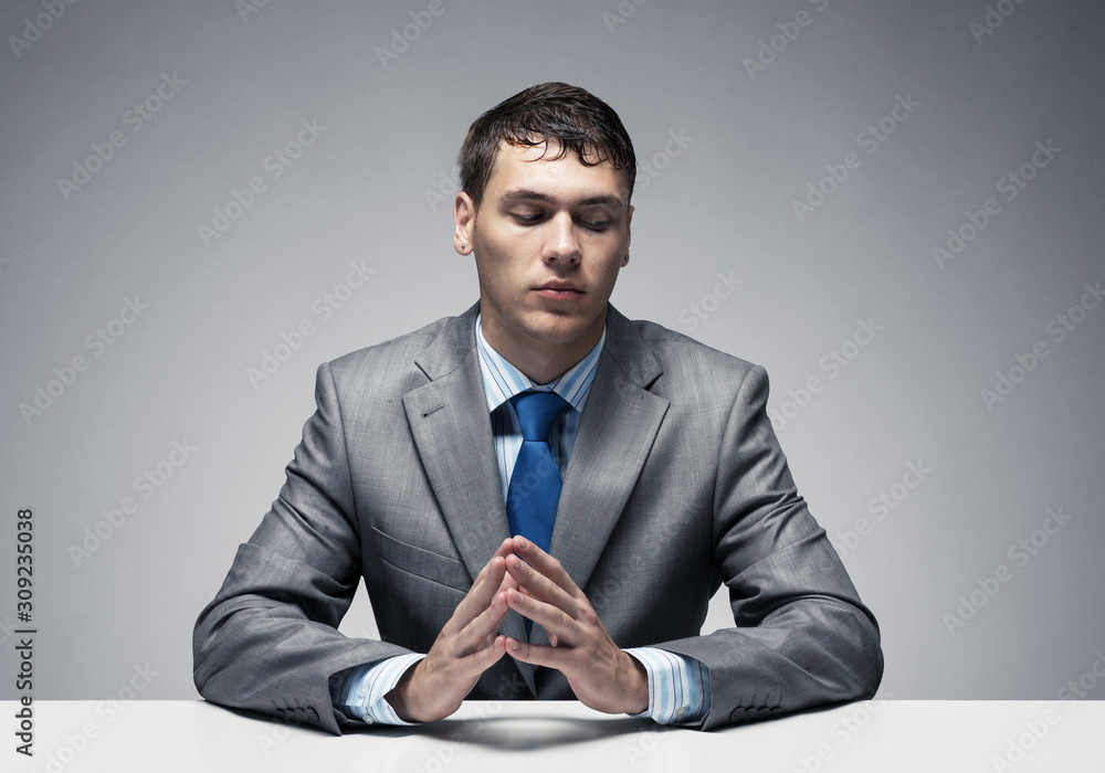 Young man folded hands and having serious face