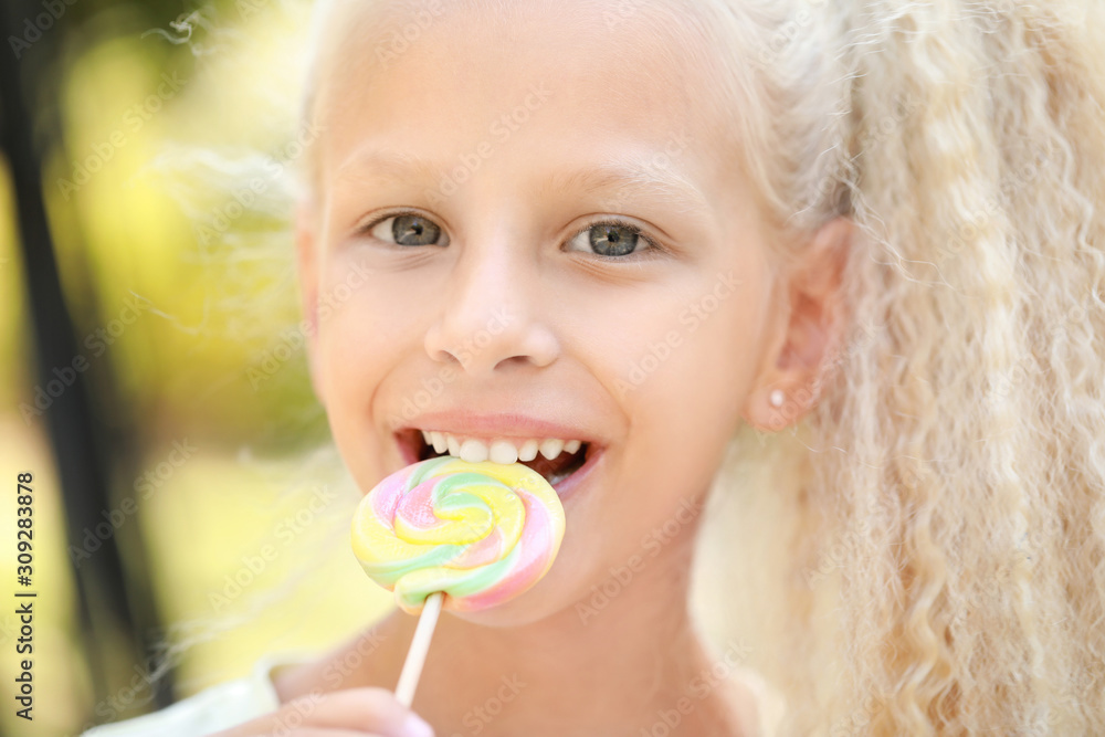 Cute little girl with lollipop outdoors