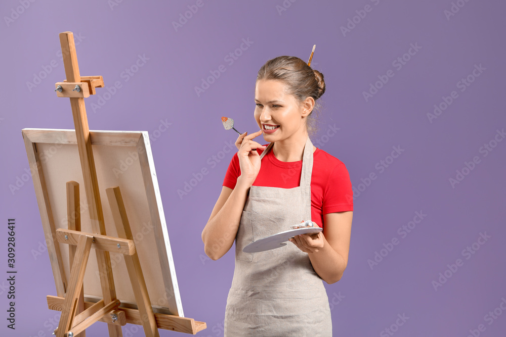 Young female artist on color background