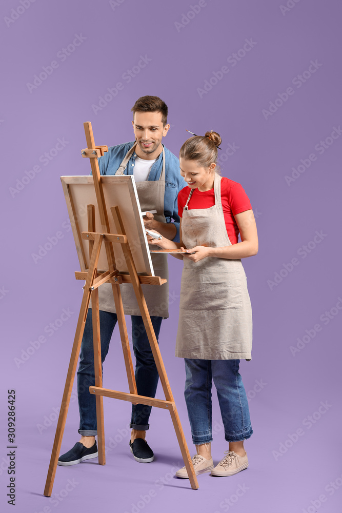 Couple of young artists on color background