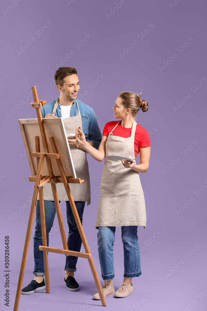 Couple of young artists on color background