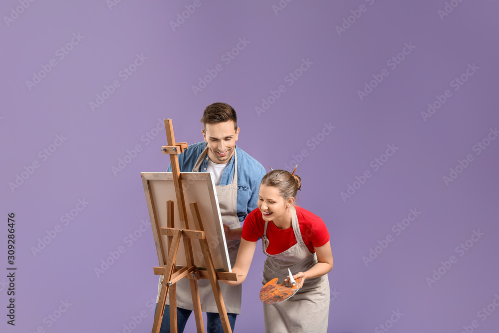 Couple of young artists on color background