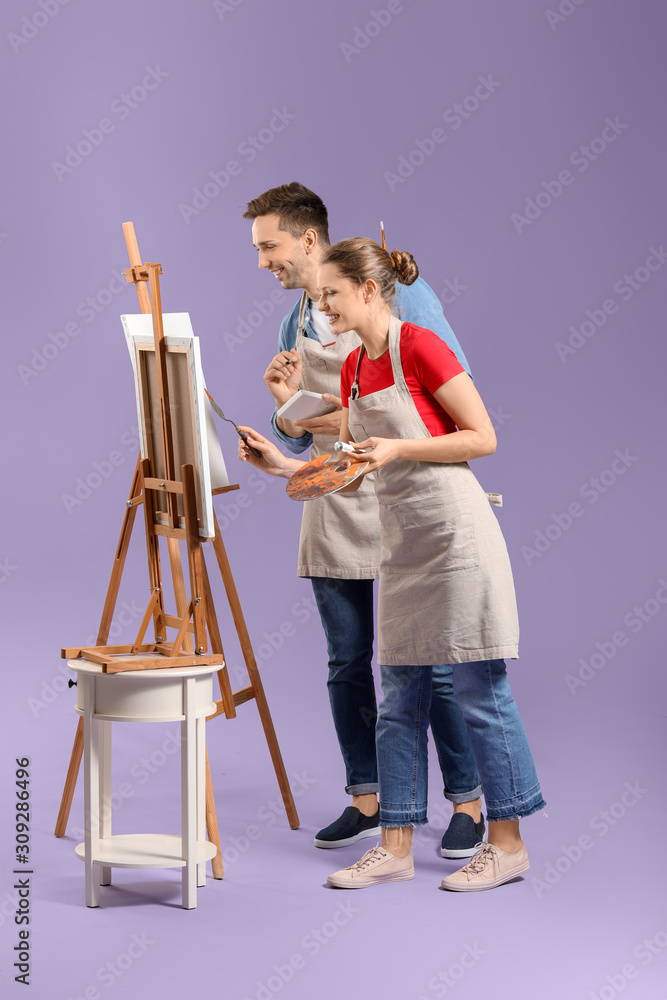 Couple of young artists on color background