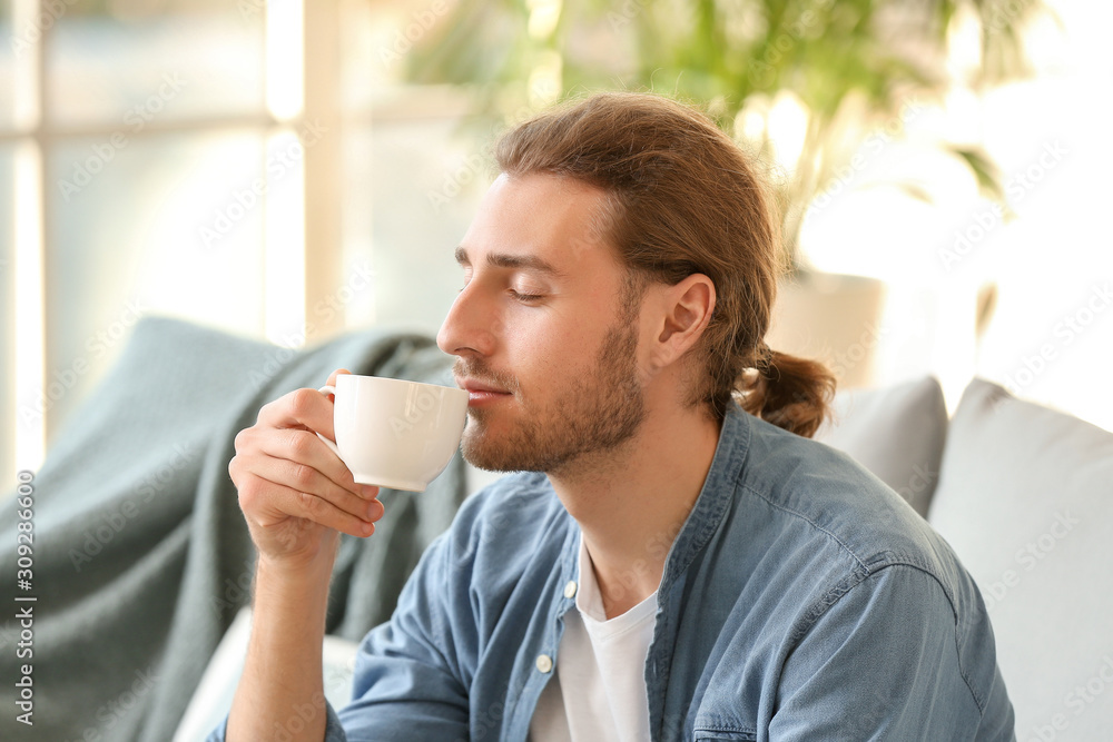 Handsome man drinking coffee at home