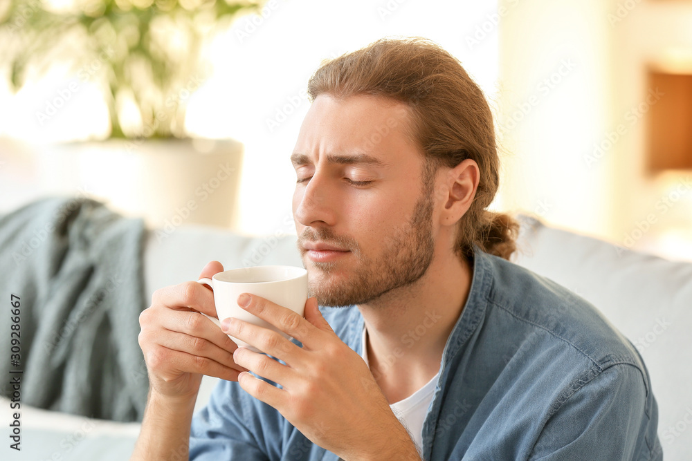 Handsome man drinking coffee at home