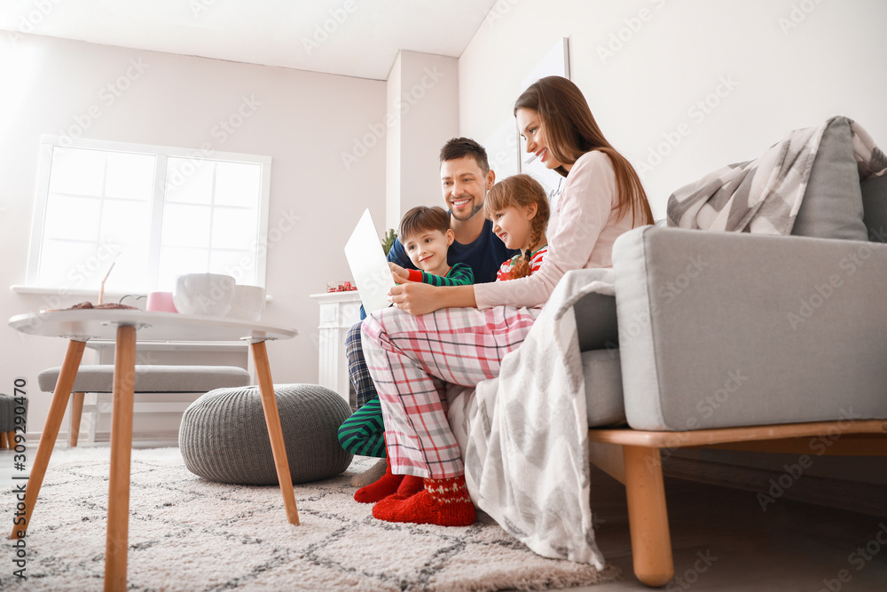 Happy family with laptop resting at home