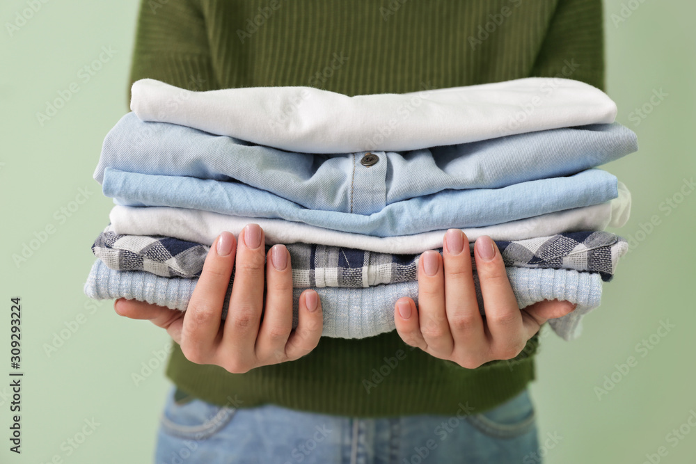 Young woman with clean clothes on color background, closeup