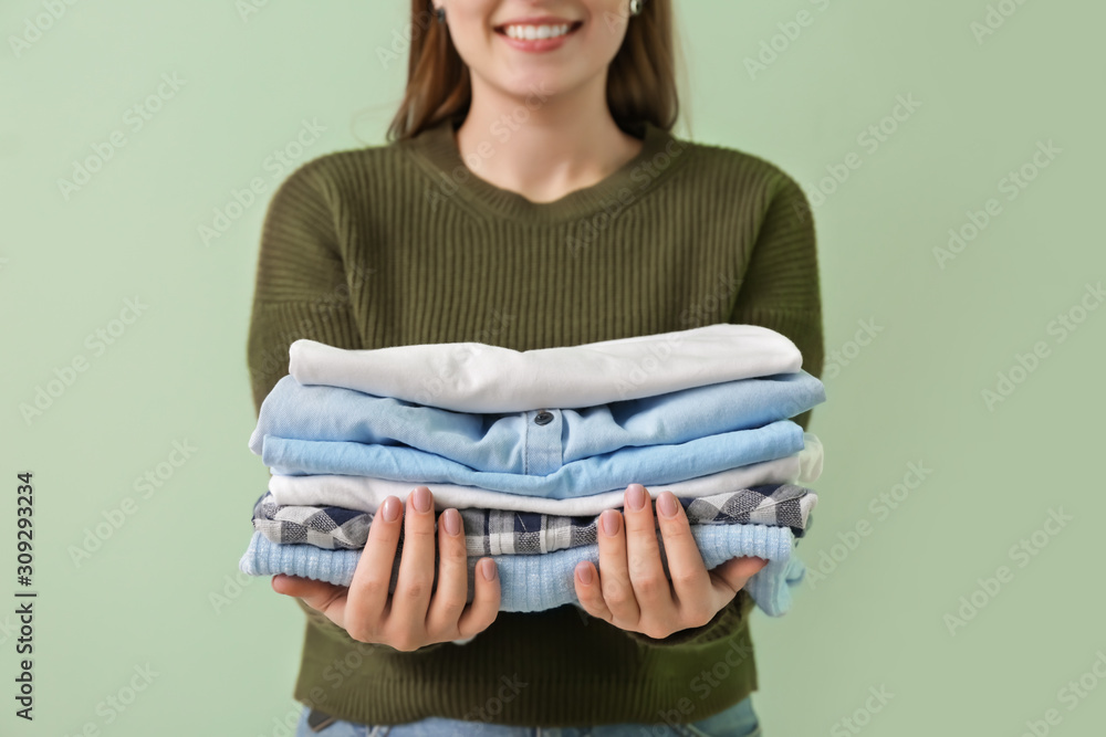 Young woman with clean clothes on color background, closeup