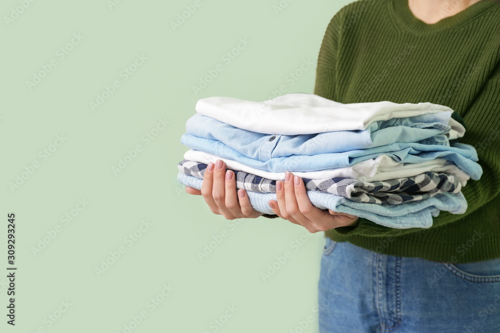 Young woman with clean clothes on color background, closeup