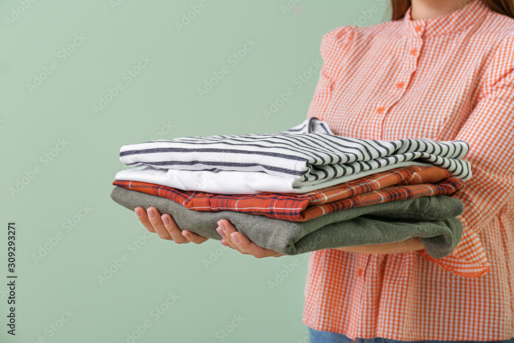 Young woman with clean clothes on color background, closeup