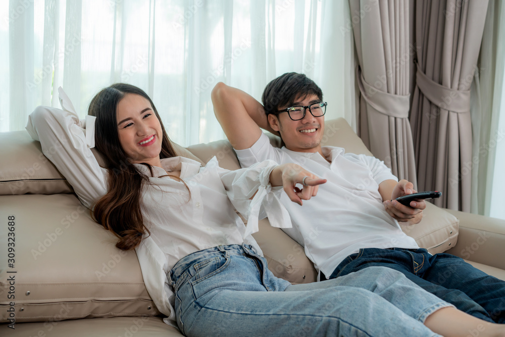 Asian couple lifestyle, man holding remote control and woman watching TV movies at home, family life