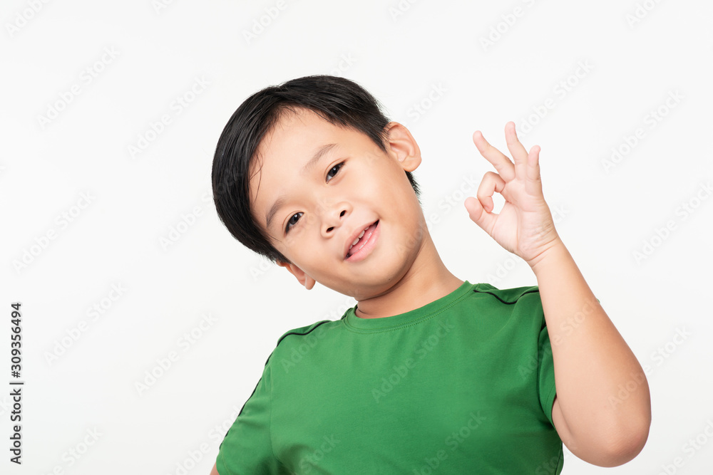 Portrait of little school boy showing OK gesture