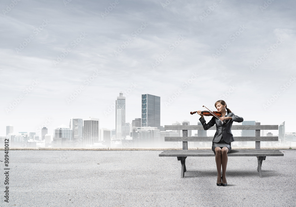 Young woman with violin sitting on wooden bench