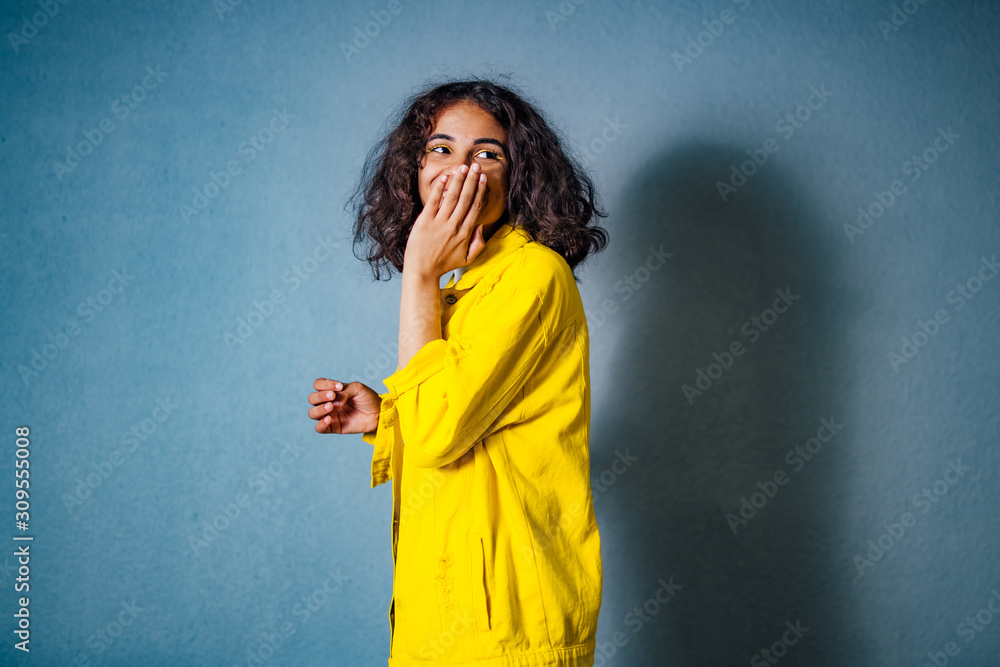 令人惊讶的美丽女孩。一位年轻女子的肖像，手放在嘴边，看起来很惊讶