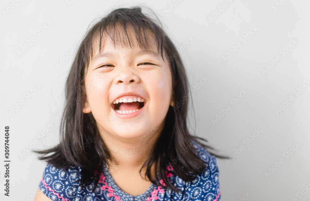 Happy Little asian girl child showing front teeth with big smile and laughing: Healthy happy funny s