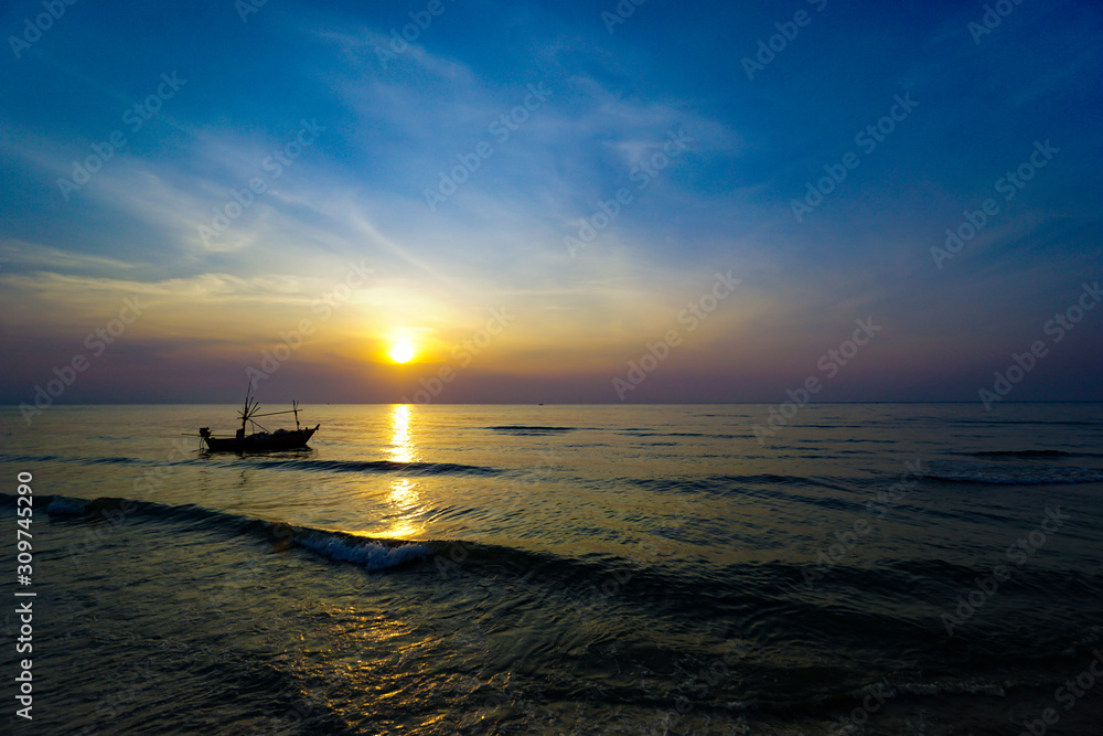 Colorful Sunrise with Sand and boat on the ocean at Huahin Thailand .