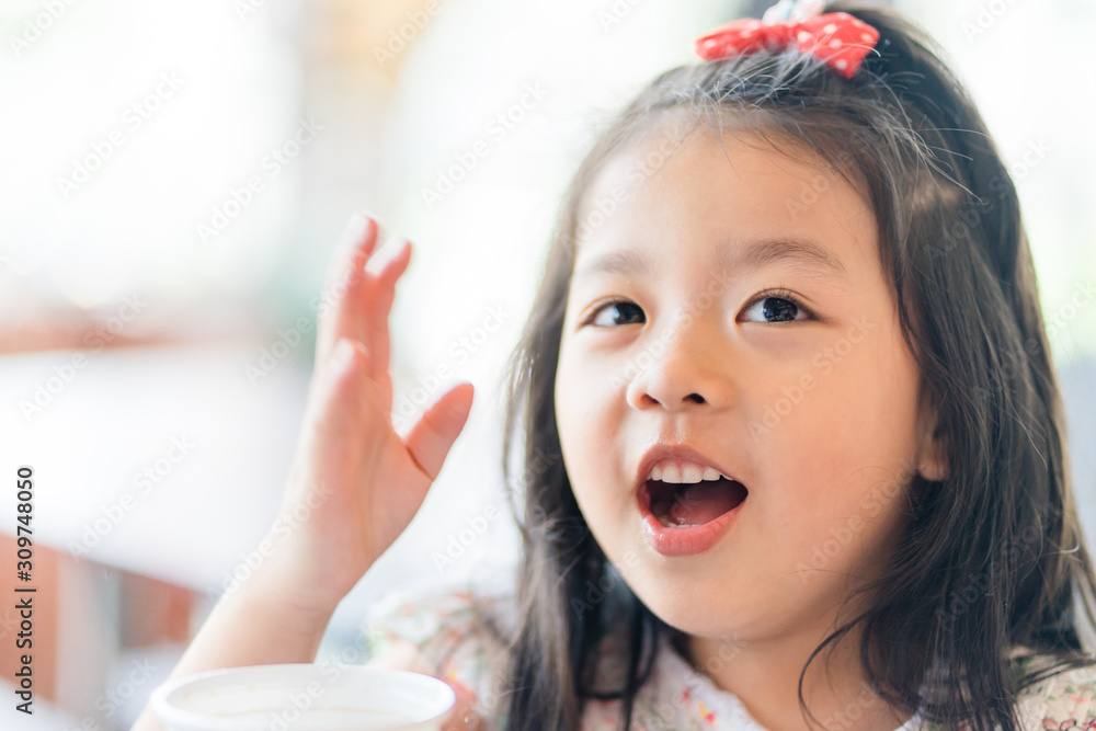 Little asian girl drinking soft drink soda in restaurant.