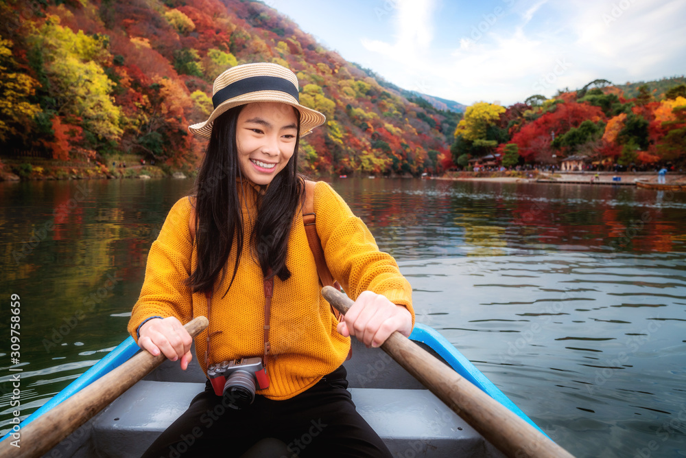 亚洲女孩在荒山公园的河边划船放松