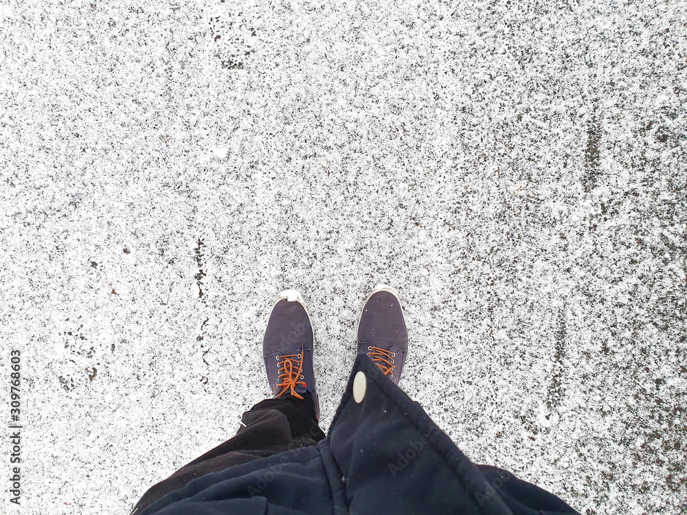 Man standing on a street slightly covered with snow