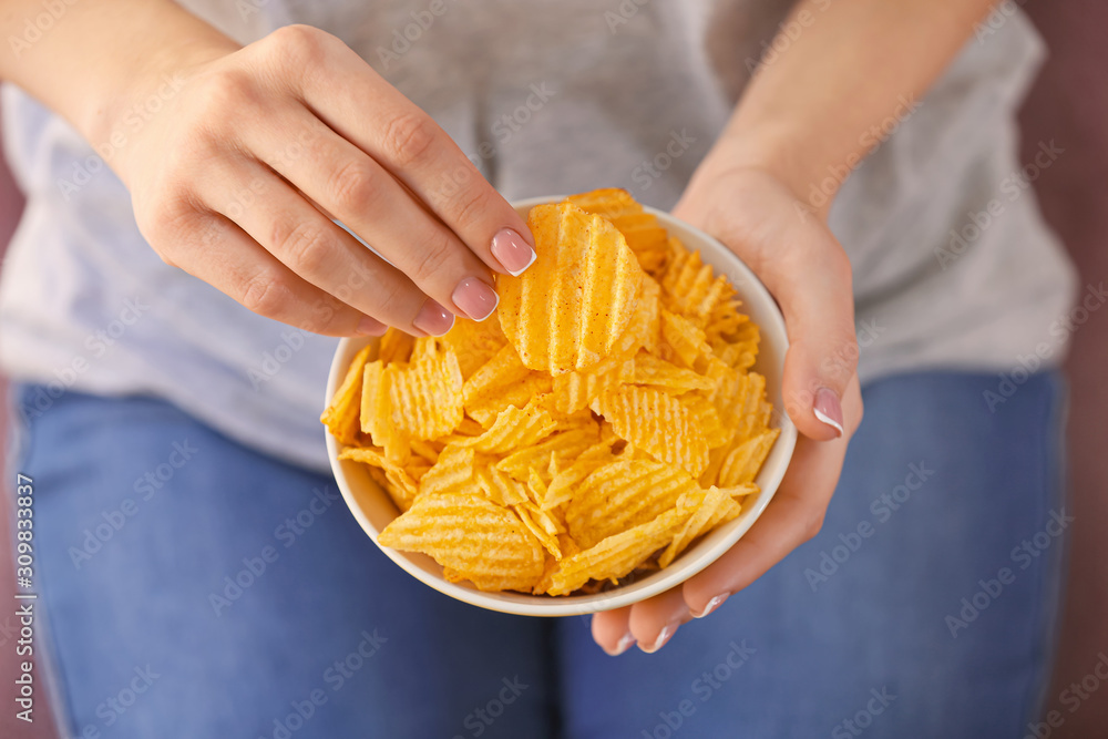 Woman eating tasty potato chips, closeup