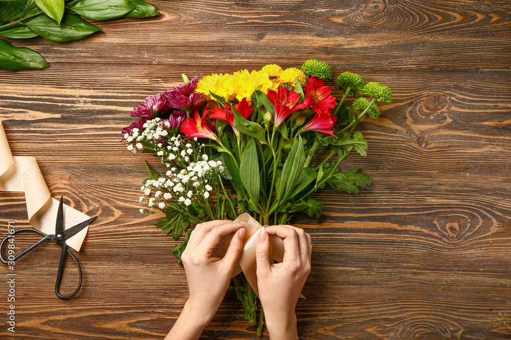 Female florist making beautiful bouquet at table