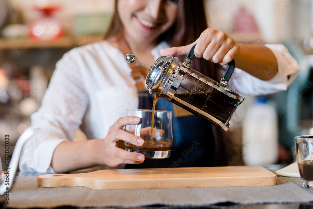 Professional Asian woman Barista preparing coffee at front counter serving coffee cup to customer oc