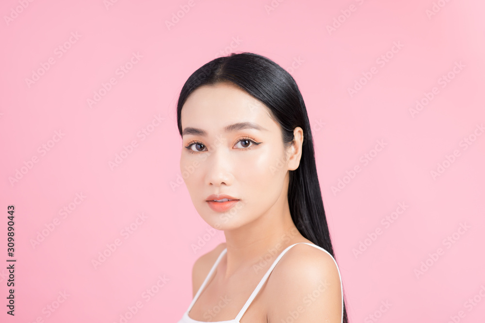 Portrait of young Asian woman with perfect skin on pink background. Concept of natural cosmetics and