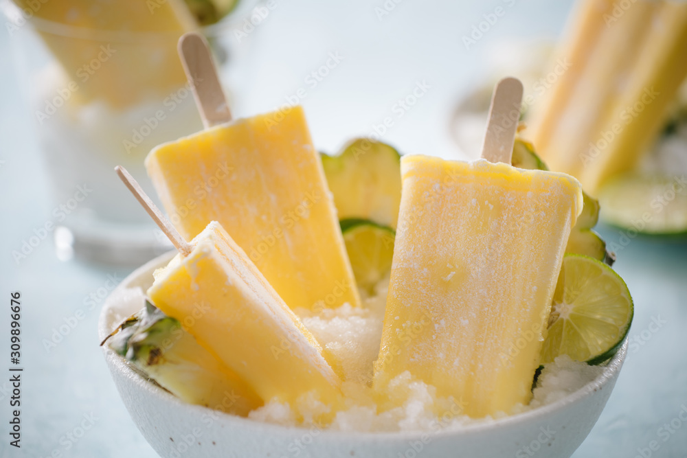 Some homemade Pineapple Popsicles (selective focus) on a rustic background