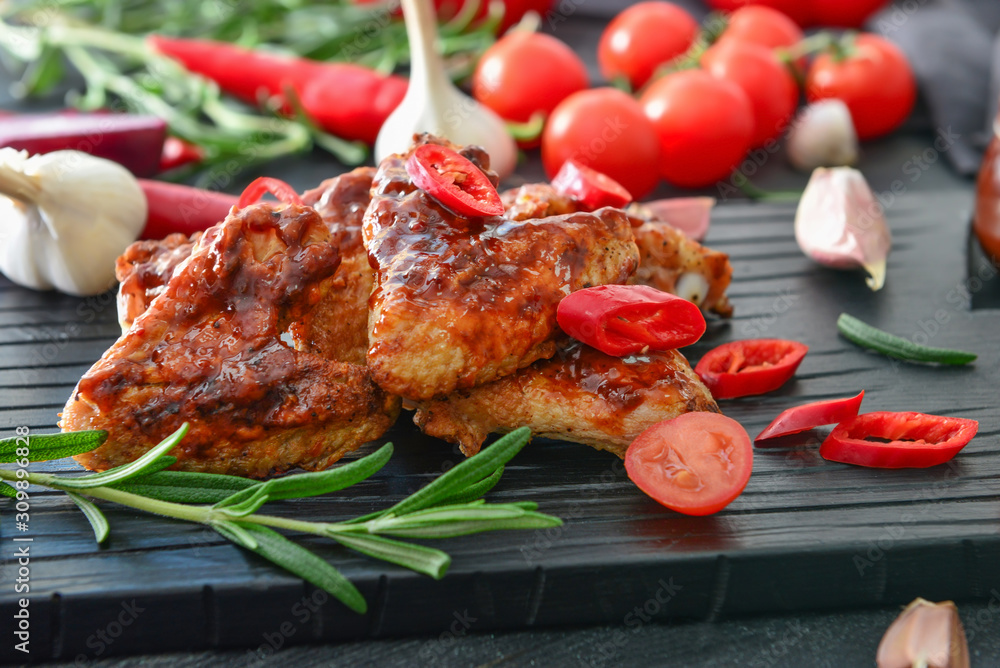 Tasty chicken wings with barbecue sauce on table