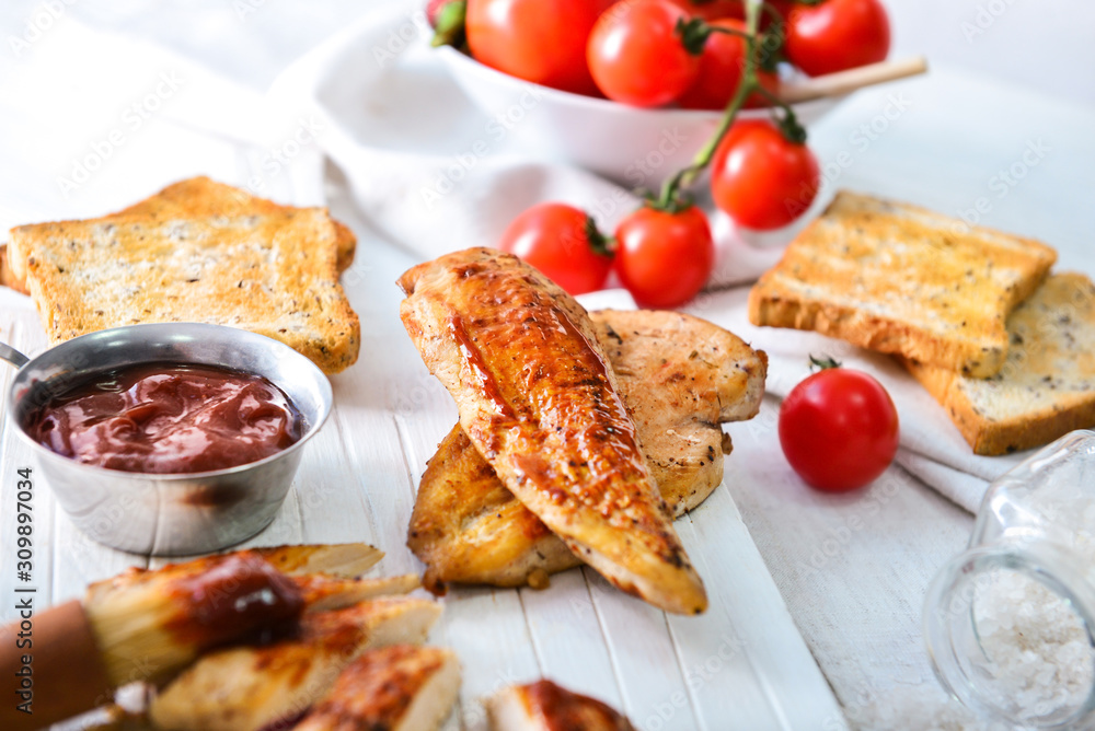 Tasty roasted chicken with barbecue sauce on white table