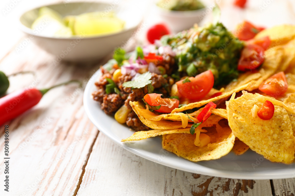 Plate with tasty chili con carne and nachos on table, closeup