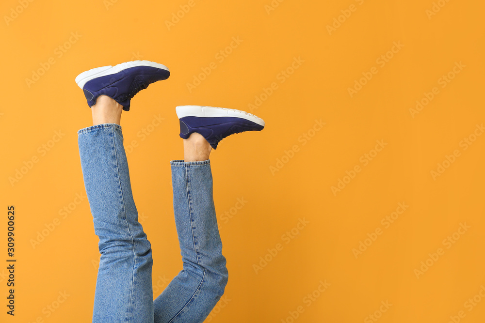 Young man in stylish shoes on color background